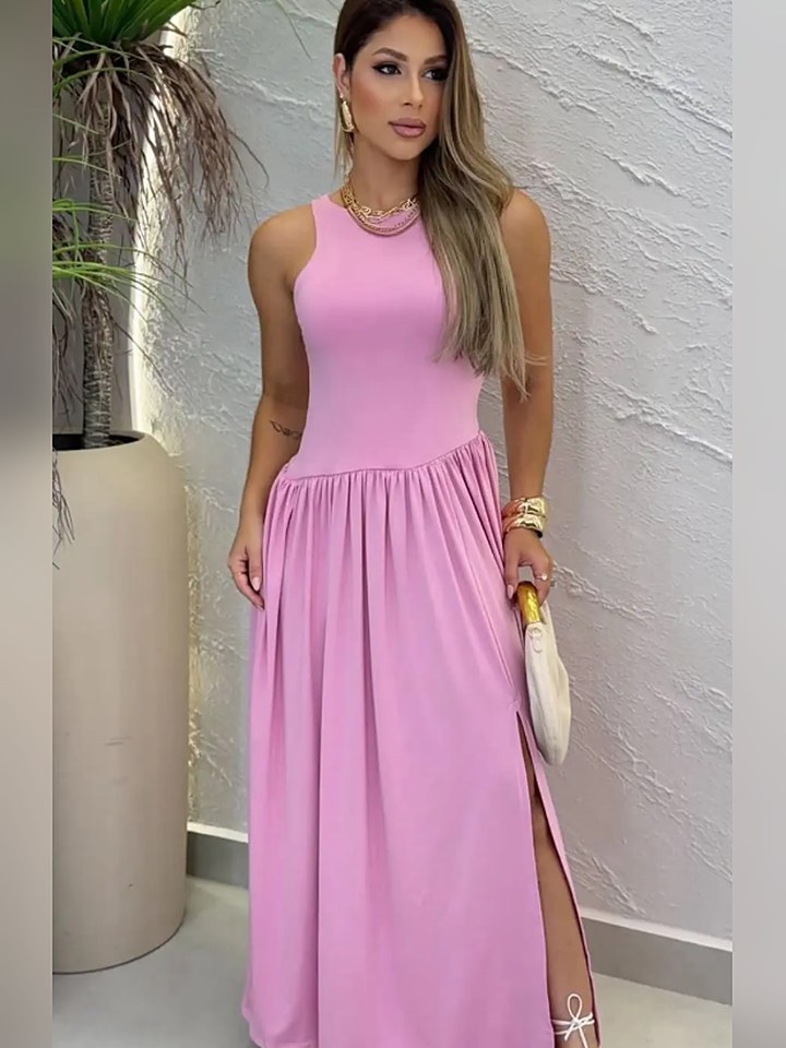 Vestido longo drapeado rosa, em ambiente com parede texturizada e arco